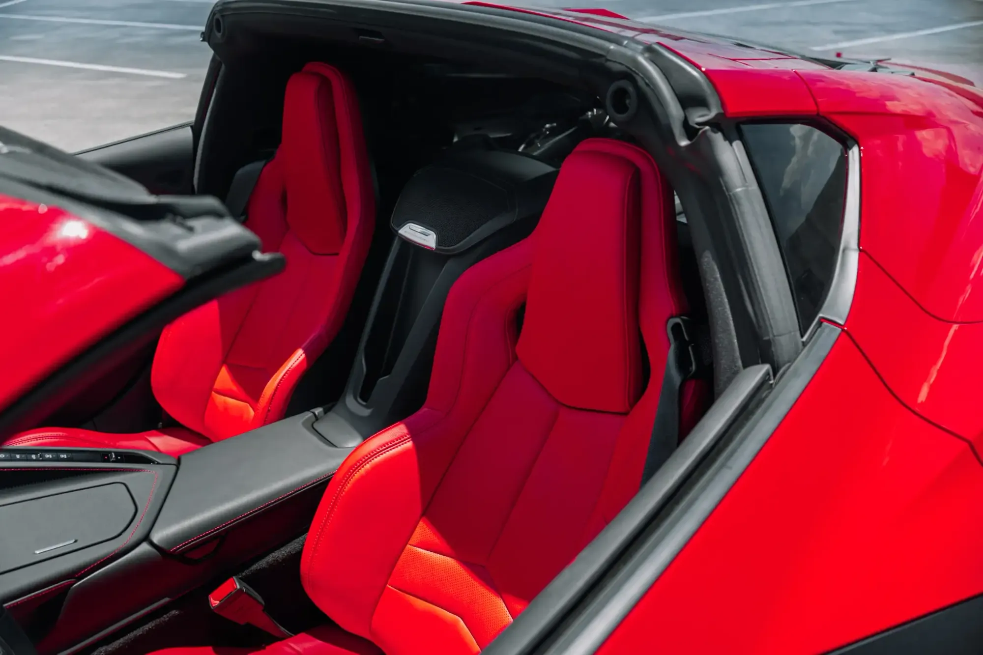 Two cheerful men laughing in the front seats of a sports car